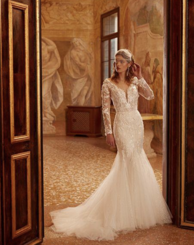 model is wearing a lace fit and flare bridal gown