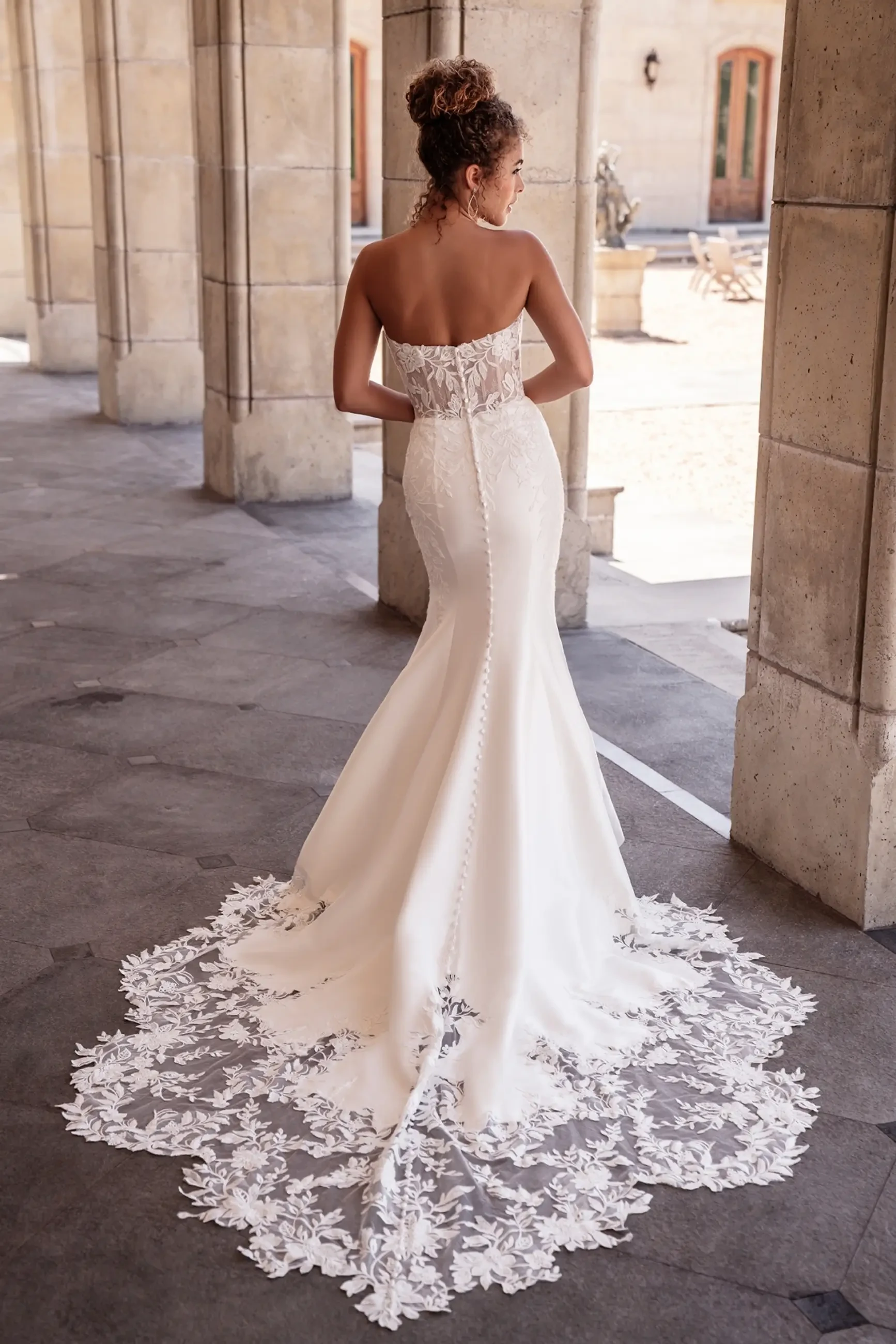 Model is wearing a strapless fit-and-flare gown made from sleek stretch Mikado.