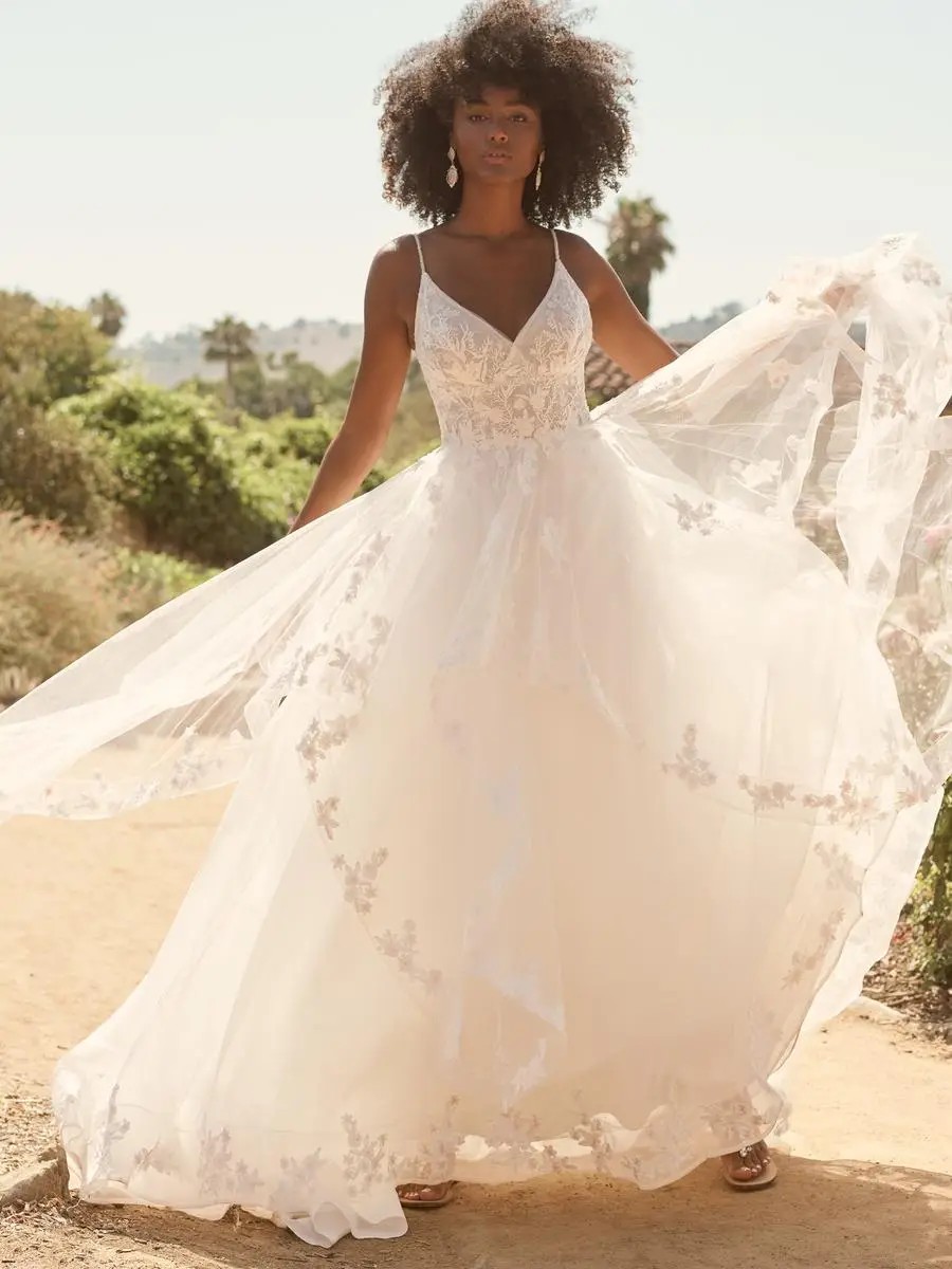 Model is wearing a lace bridal gown by maggie sottero
