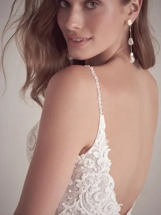 Model is wearing a chiffon sleeveless wedding dress by maggie sottero