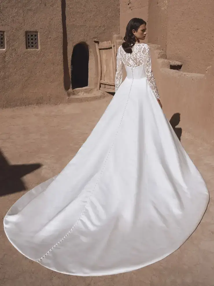 model is wearing a long sleeve wedding dress