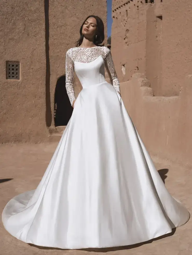 model is wearing a long sleeve wedding dress