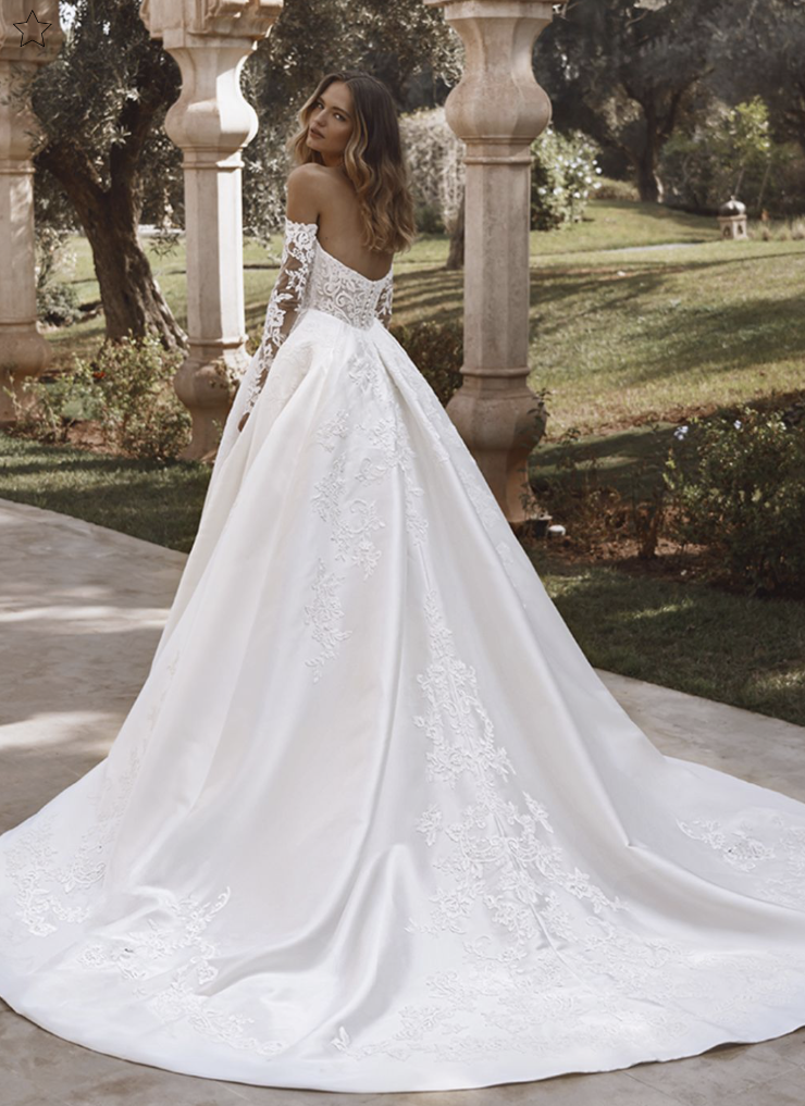 model is wearing a strapless ball gown wedding dress with lace gauntlet sleeves