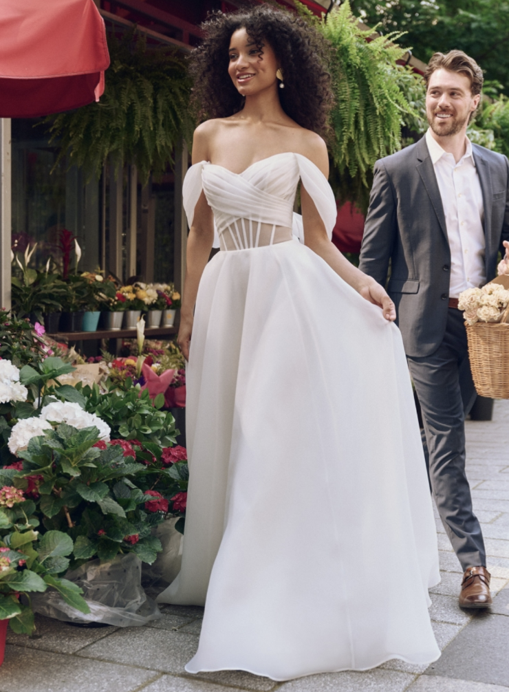 model is wearing an off the shoulder a-line bridal gown